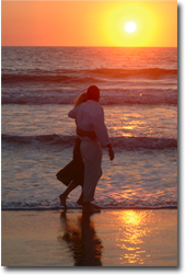 Couple walking on beach at sunset